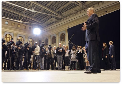 Prime Minister Vladimir Putin talks to reporters following his televised Q&A session