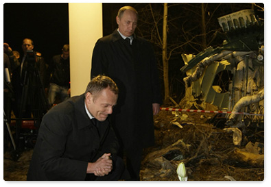 Russian Prime Minister Vladimir Putin and Polish Prime Minister Donald Tusk lay flowers next to a piece of the wreckage from the Tu-154 plane crash