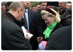 Перед тем, как покинуть Мемориал, Председатель Правительства России В.В.Путин роздал пару автографов собравшимся у храма жителям поселка|29 мая, 2010|19:15