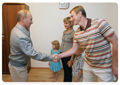 Vladimir Putin speaking to a family in one of the new low-rise residential development in Kotelnikovo after visiting the Gremyachin potassium salt deposits|15 july, 2010|20:58