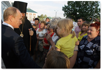 Prime Minister Vladimir Putin visits a church in the village of Tulinovka and assists a farmer in getting a loan