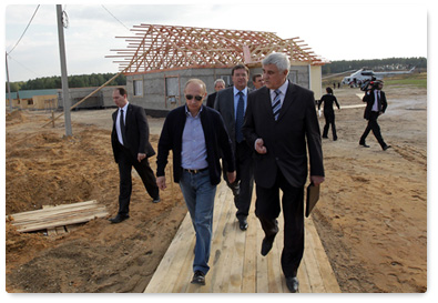 Prime Minister Vladimir Putin surveys the progress of housing construction for wildfire victims in the village of Ivatino in the Vladimir Region and talks with future residents