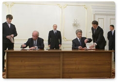 Prime Minister Vladimir Putin looks on as Novatek and France’s Total sign cooperation memorandums