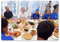 Prime Minister Vladimir Putin speaks with scientists and archaeology students working on the excavation of the ancient Greek city of Phanagoria