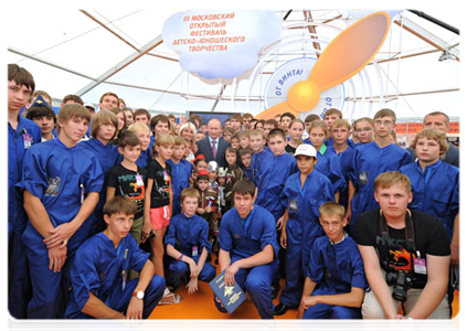 Prime Minister Vladimir Putin being photographed with children at the end of his visit to the pavilion of the Clear Prop open festival of children's creative endeavours in Moscow|17 august, 2011|20:54