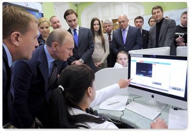 Prime Minister Vladimir Putin reviews the system for the webcam monitoring of polling stations during his visit to the 2012 election monitoring centre