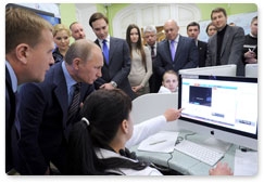 Prime Minister Vladimir Putin reviews the system for the webcam monitoring of polling stations during his visit to the 2012 election monitoring centre